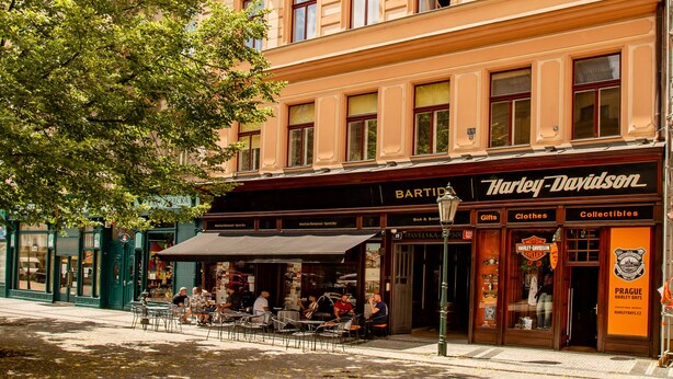 Ein mehrstöckiges Gebäude mit einem Laden im Erdgeschoss, auf dem "Harley-Davidson" steht.