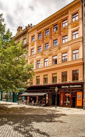A multi-story building with a storefront labeled "Harley-Davidson" on the ground floor. - Residence St. Havel Prague Old Town (Prague)