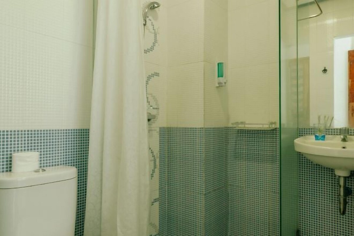 A bathroom with a shower, toilet, and sink.