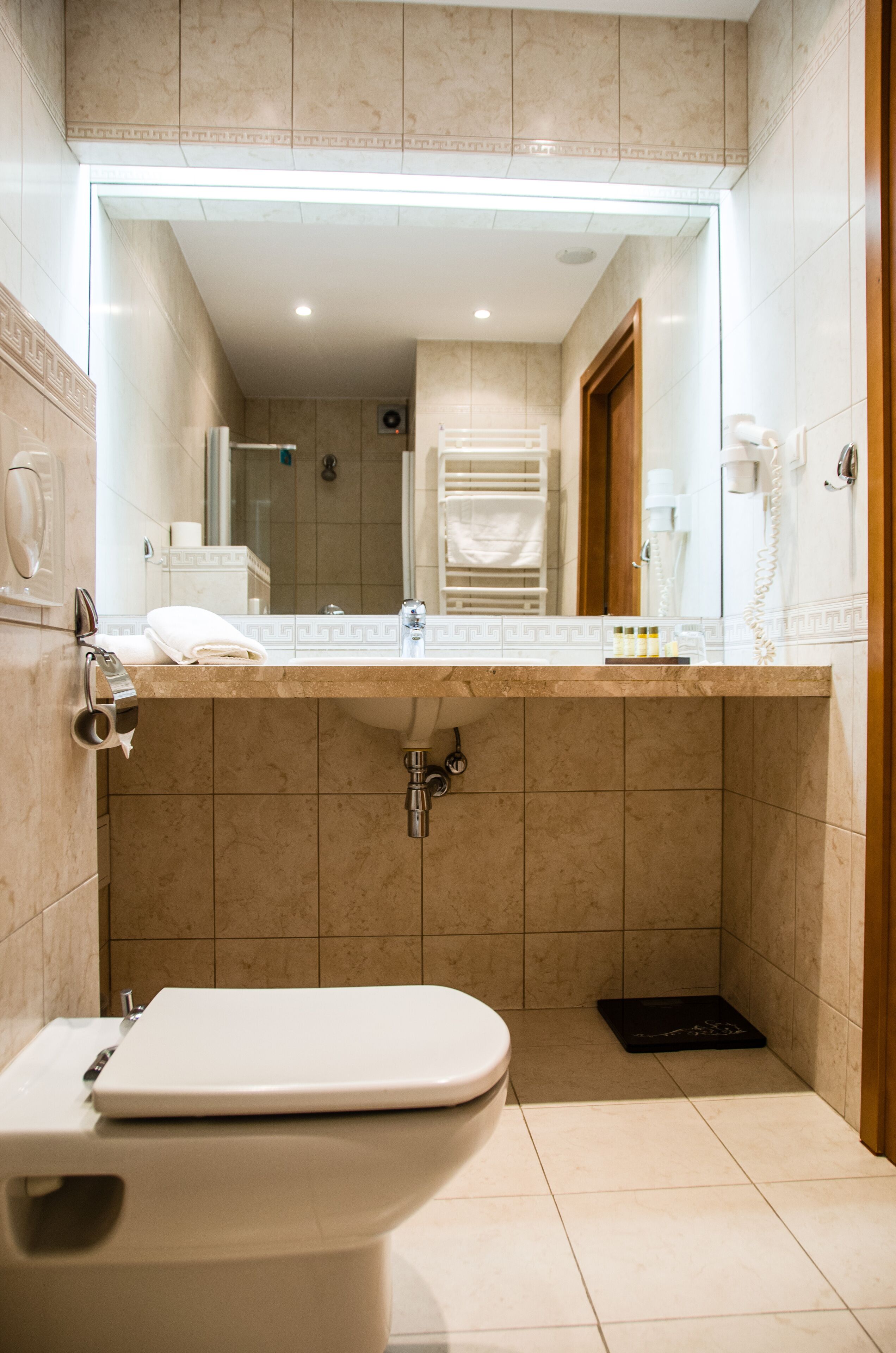 Ein Badezimmer mit Toilette, Waschbecken und Spiegel.