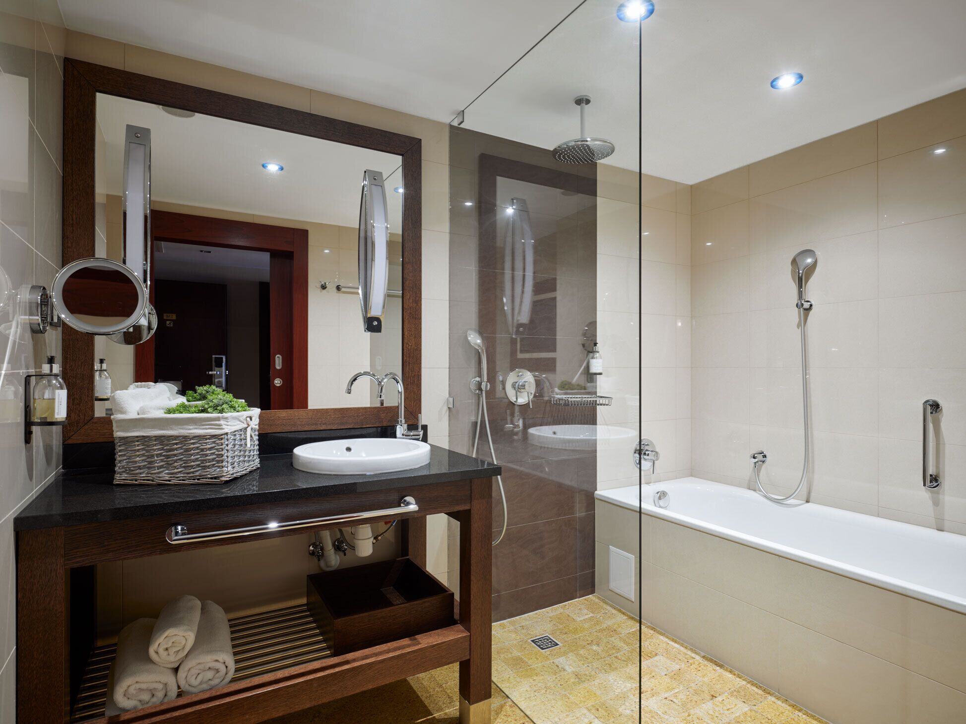 A modern bathroom with a vanity, a large mirror, a shower, and a bathtub.
