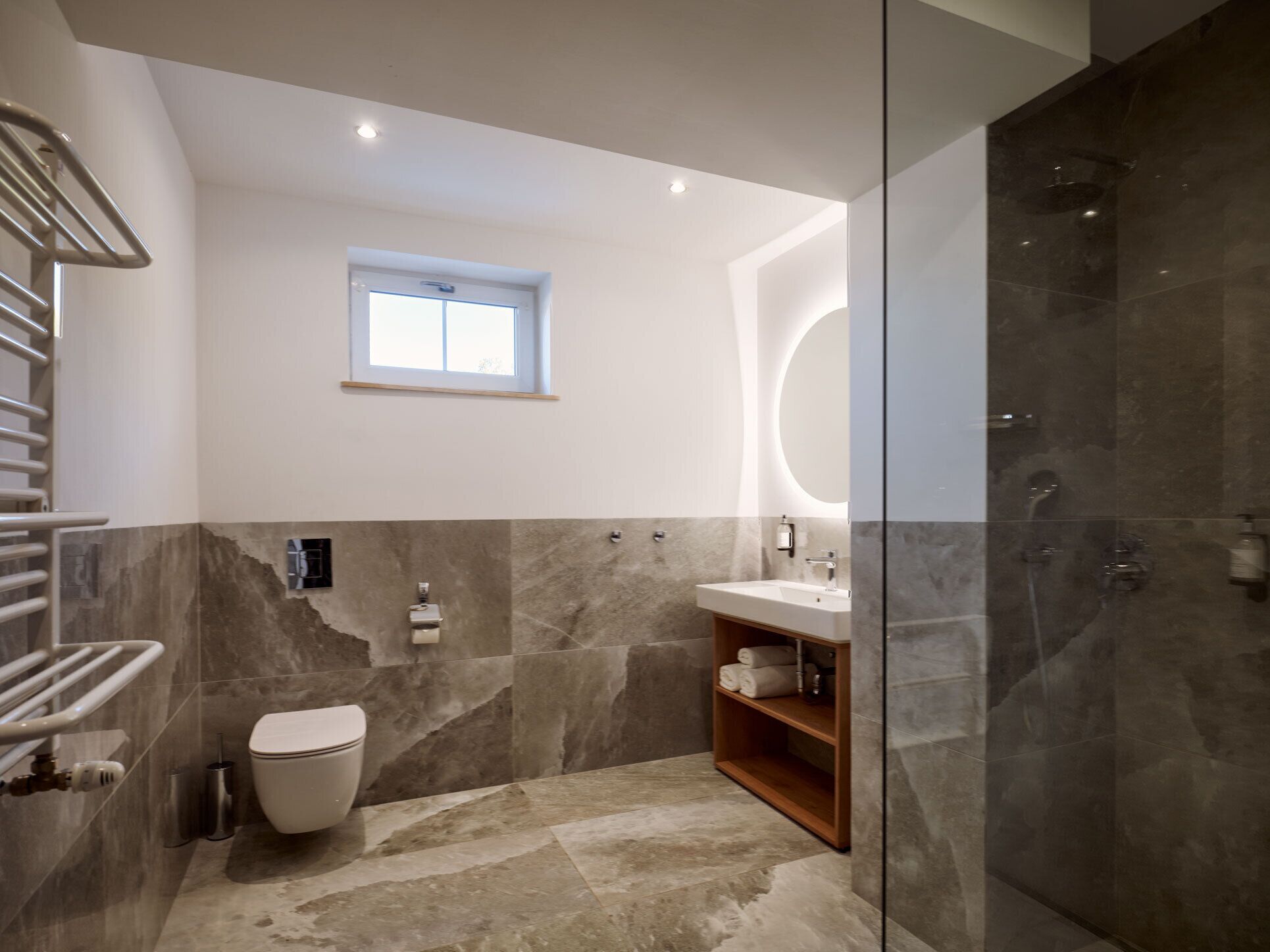 A modern bathroom with a toilet, sink, and shower.