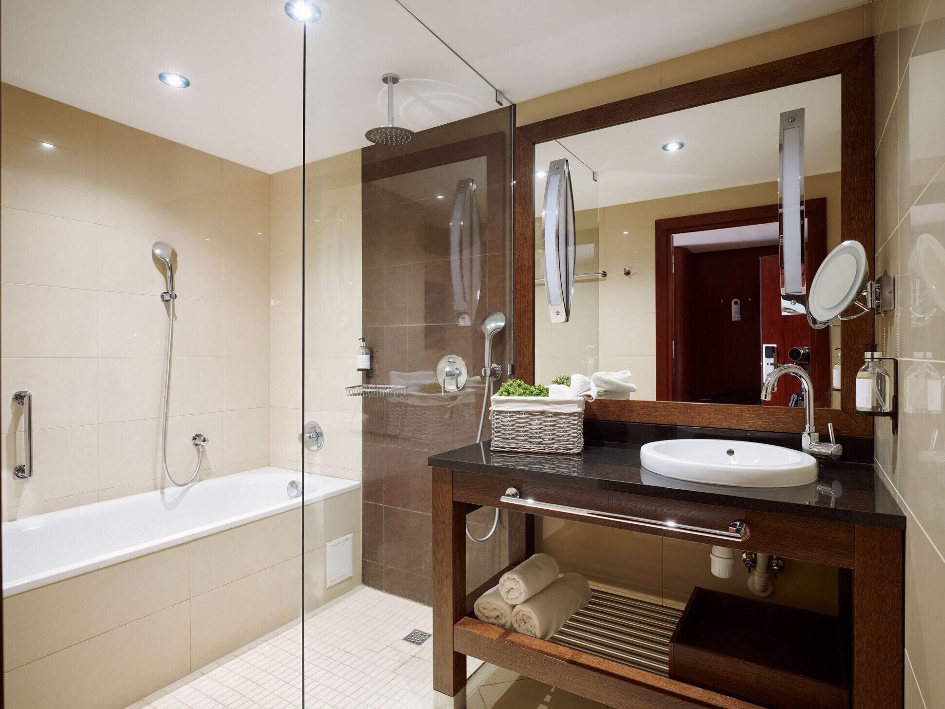 A modern bathroom with a glass-enclosed shower, a freestanding bathtub, and a vanity with a sink and mirror.