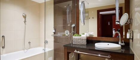 A modern bathroom with a glass-enclosed shower, a freestanding bathtub, and a vanity with a sink and mirror.