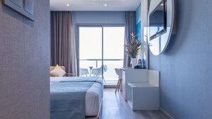 Une chambre d’hôtel moderne, dotée d’un grand lit, d’un bureau et offrant une vue sur l’extérieur.