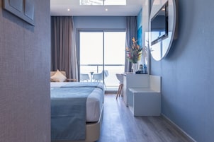 Una moderna camera d'albergo con un letto grande, una scrivania e vista sull'esterno.
