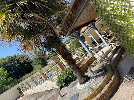 Piscine extérieure (ouverte en saison), chaises longues. Hôtel Le RELAX