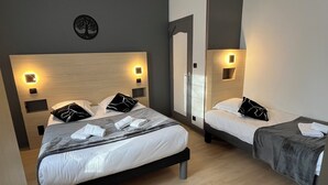 A hotel room with two beds, each with a headboard, bedside tables, and wall-mounted lights. - Hôtel Le RELAX (Boulazac-Isle-Manoire)