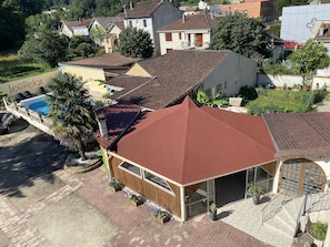 Un edificio con techo rojo, piscina y un letrero que dice "Le Relax".
