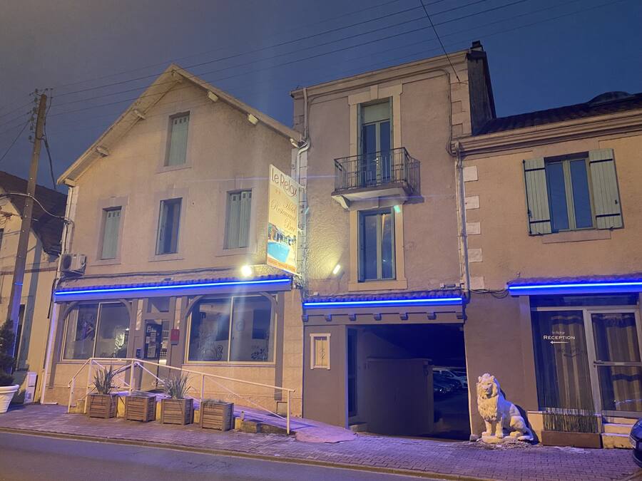 Un edificio con un cartel que dice 'Le Relais Hotel Restaurant Bar'.