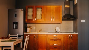 A kitchen with wooden cabinets, a stainless steel refrigerator, a coffee maker, and a toaster. - Elite Apartments Seaview Horyzont (Gdansk)