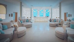 Un vestíbulo amplio con una recepción central, diversas zonas de estar y un diseño arquitectónico moderno.