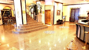 A lobby with a marble floor, a reception desk, a staircase, and a large plant. - Business Park Hotel (Ankara)