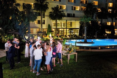 Una piscina al aire libre, sombrillas, sillones reclinables de piscina