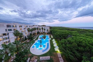A resort with a large swimming pool, multiple floors of rooms, and lush greenery. - Estival Isla Cristina (Isla Cristina)