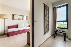 A hotel room with a bed, a bedside table, a lamp, a window with a view, and a wall-mounted artwork. - Estival Isla Cristina (Isla Cristina)