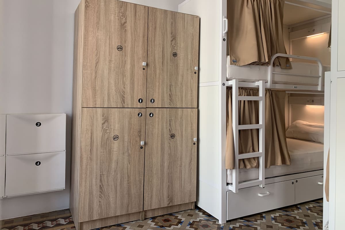 A bunk bed with a ladder and a wardrobe with four drawers.