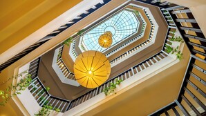 A multi-level atrium with a glass ceiling, multiple staircases, and decorative lighting fixtures. - Lantana Riverside Hoi An Hotel (Da Nang)