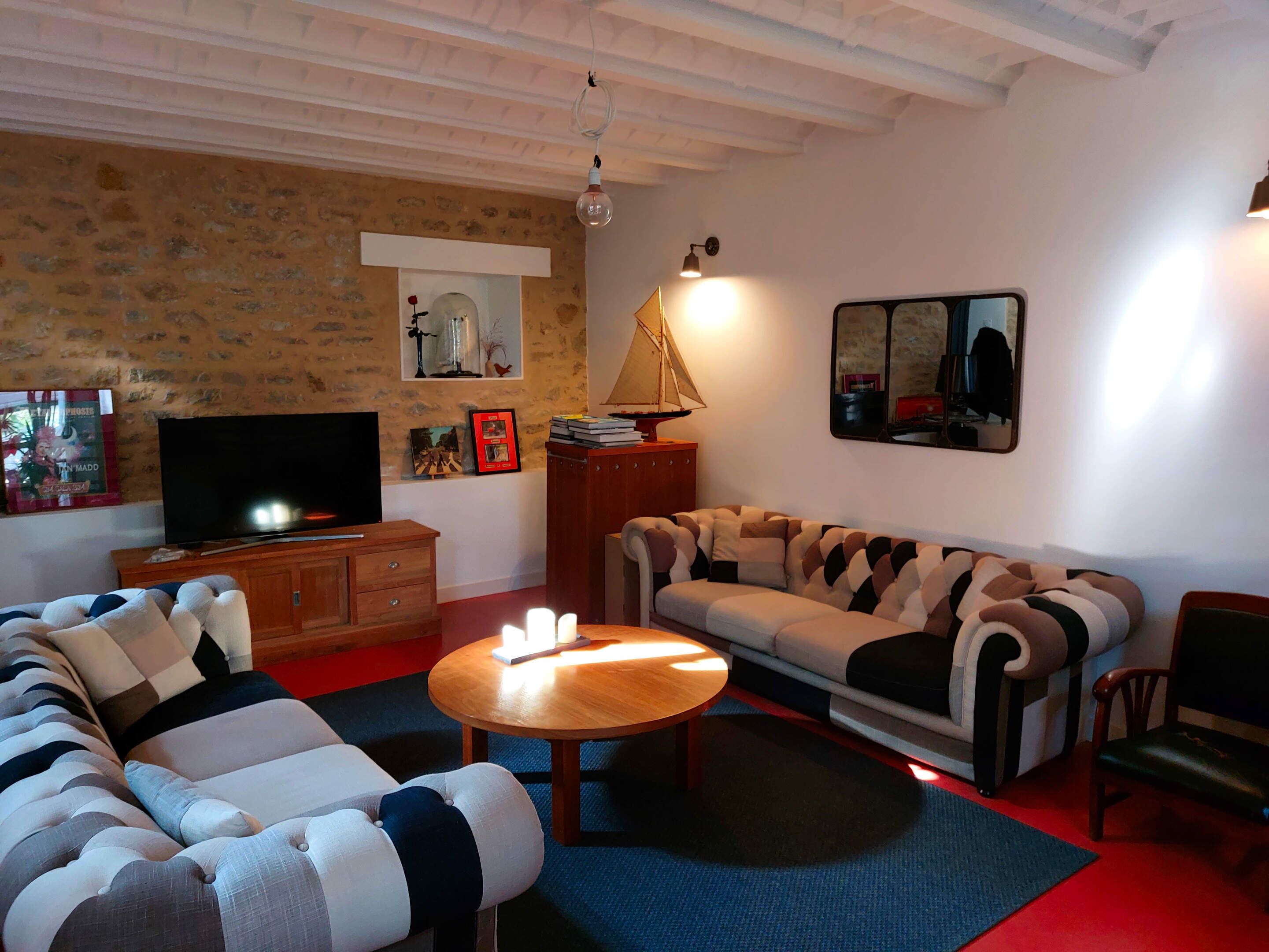 A living room with a sofa, a wooden coffee table, a television, and a lamp.