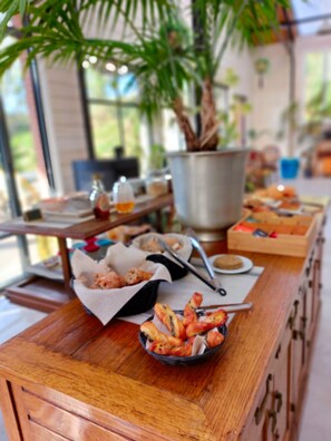 A buffet table with various food items, a metal bucket, and a potted plant. - Laiterie de Tocqueville (Tocqueville)