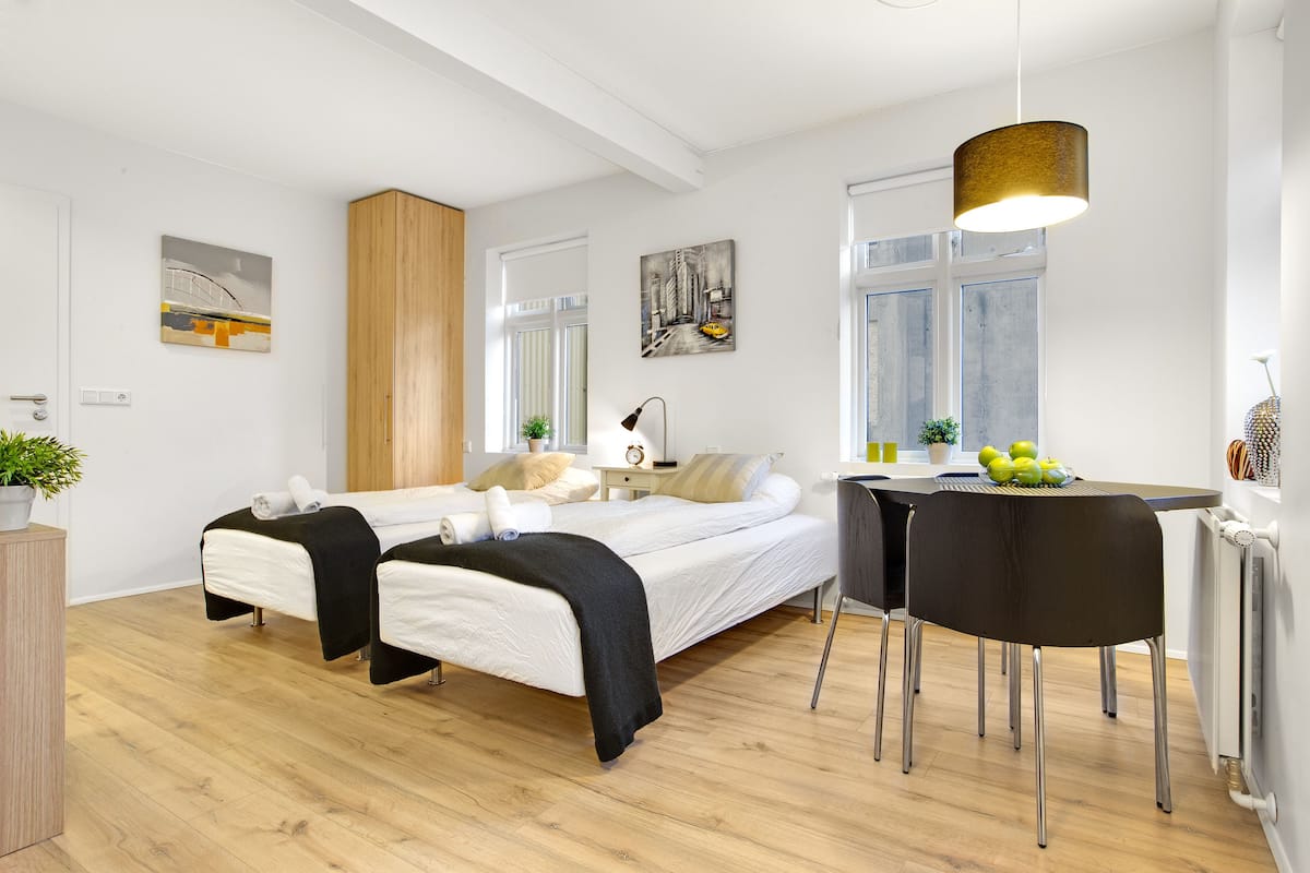 Um quarto moderno com cama, mesas de cabeceira, escrivaninha e uma cadeira.