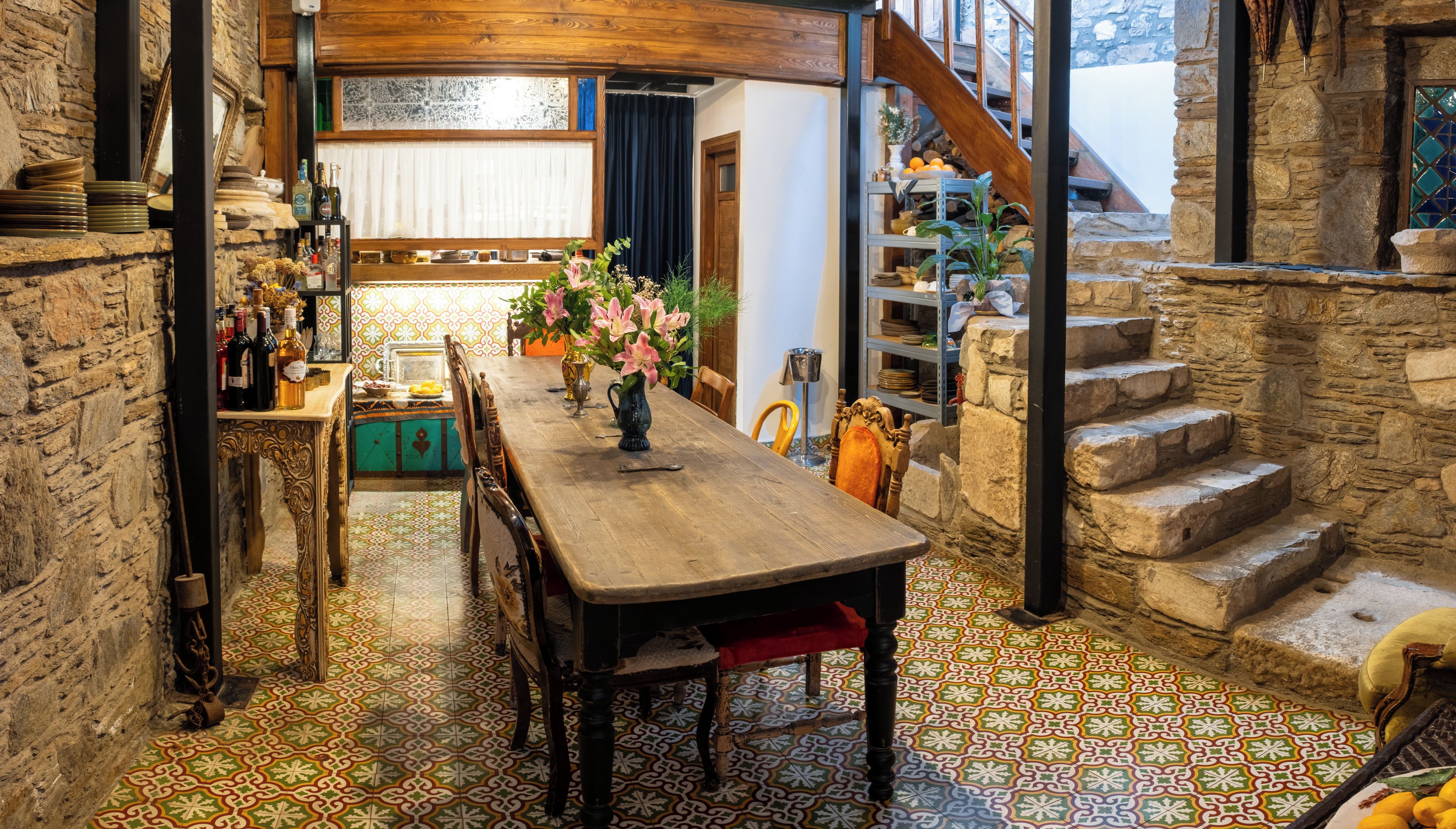 Un comedor con mesa de madera, sillas y piso con diseño.