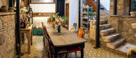 Un comedor con mesa de madera, sillas y piso con diseño.
