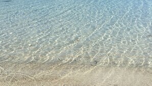 A clear view of a beach with shallow, clear water and a sandy shore. - Deniz Kabugu Hotel (Cesme)