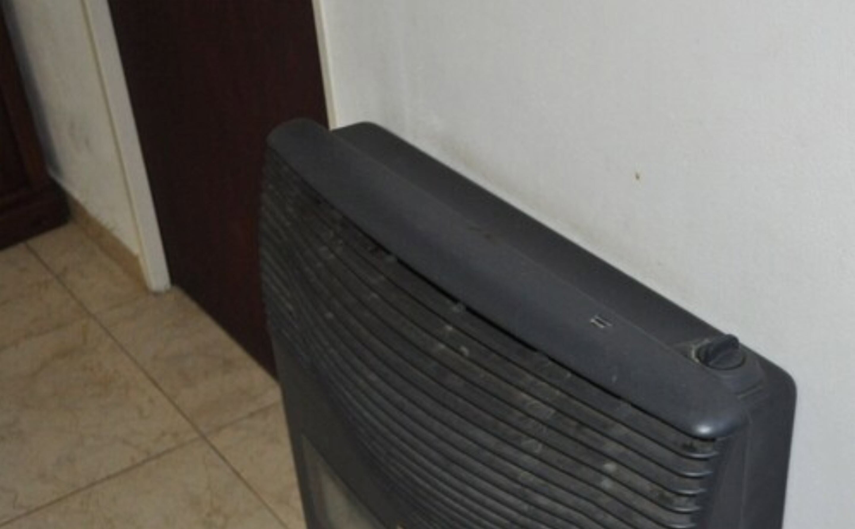 Un radiador negro sobre un muro blanco.