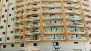 A multi-story building with balconies on each floor, a flat facade, and a uniform architectural style. - Jewel Mandara Apartments (Alexandria)