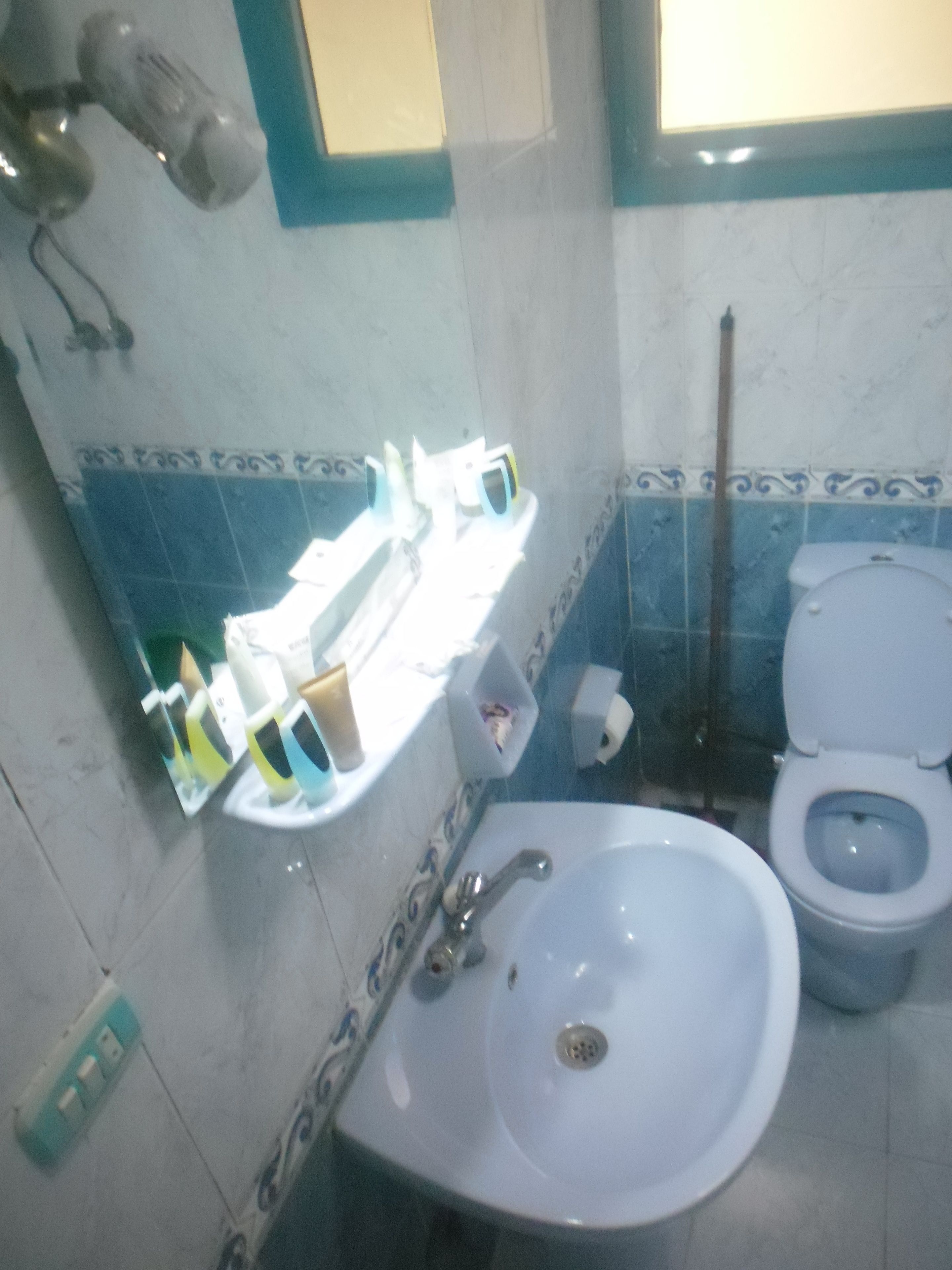 A bathroom with a sink, toilet, and shower area.
