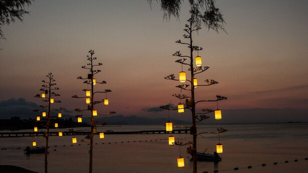 A beachside area with lounge chairs and decorative light fixtures. - Orcey Hotel (Datça)