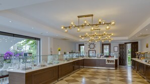 A modern kitchen with a checkered floor, a glass-top buffet, and a decorative chandelier. - Orcey Hotel (Datça)