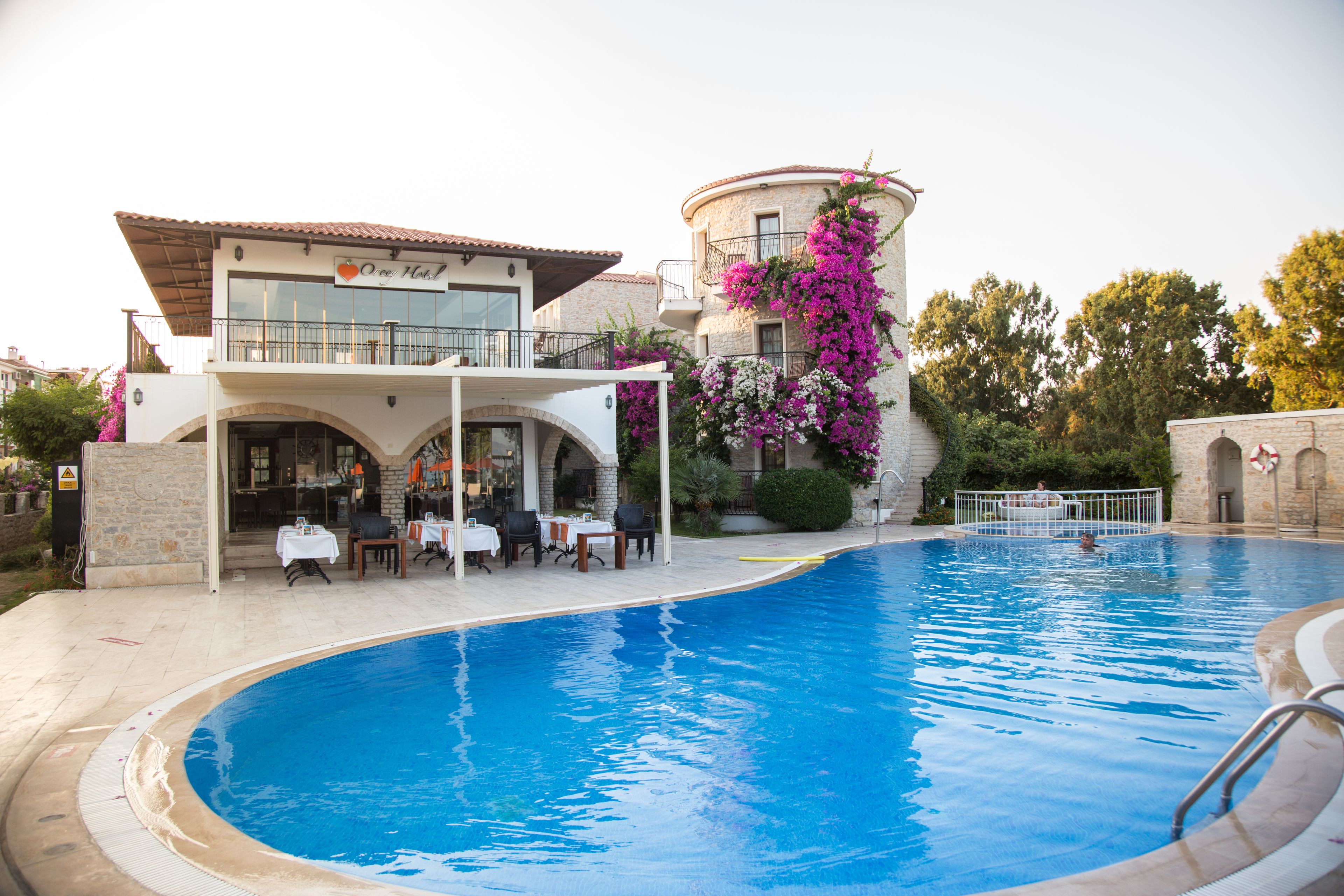 Una piscina al aire libre, sombrillas, sillones reclinables de piscina