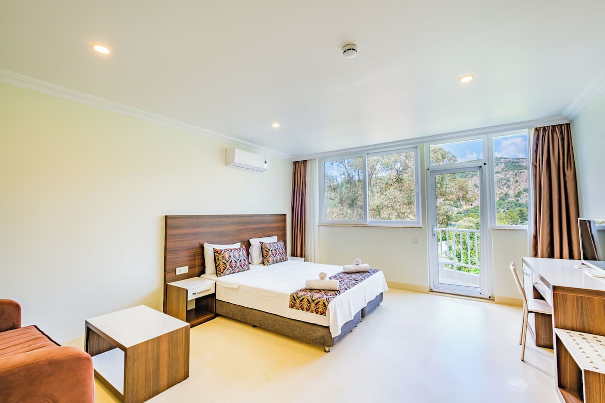 Habitación Deluxe, vistas parciales al mar | Caja fuerte, escritorio, wifi gratis y ropa de cama