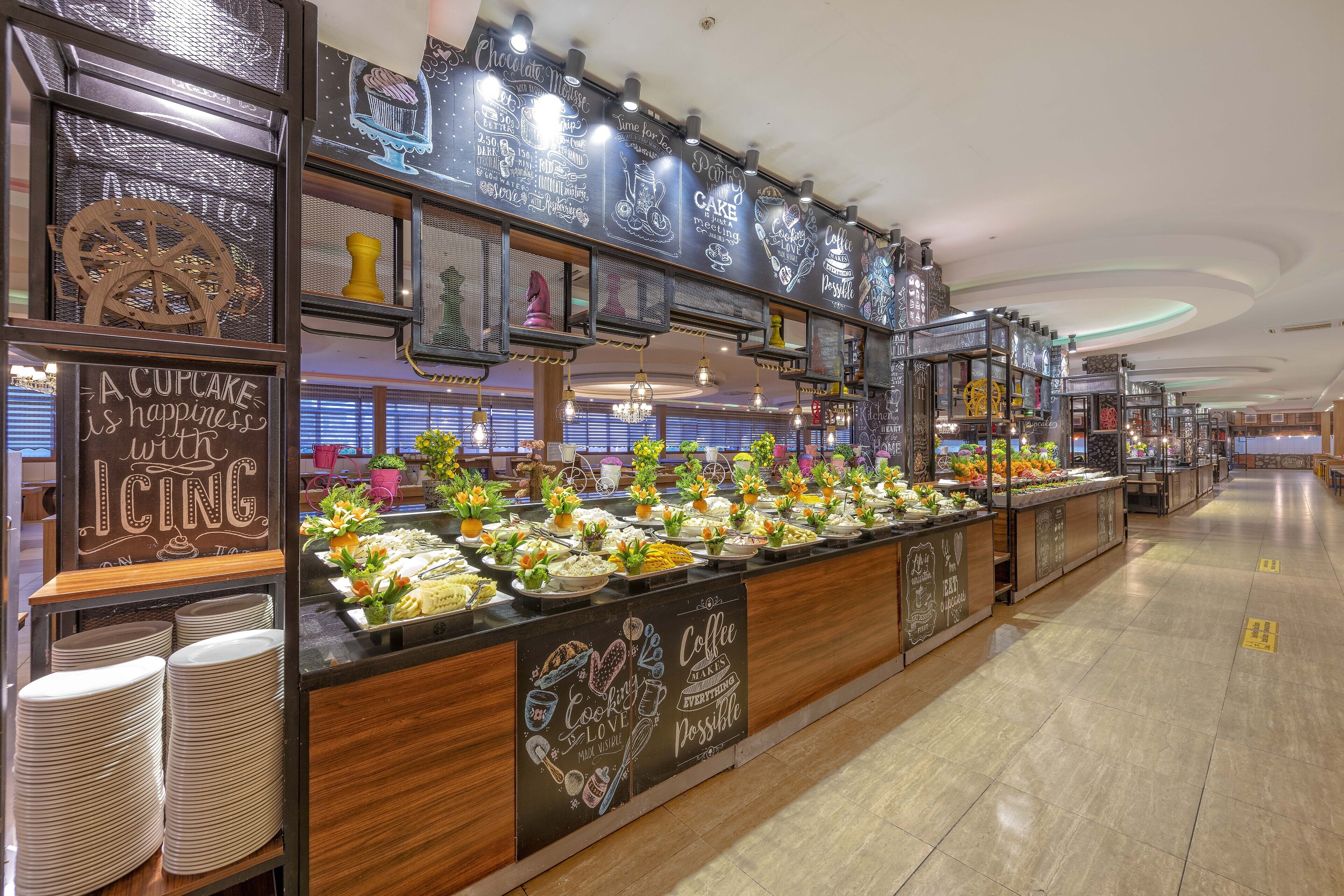 Un espace buffet avec différents stands de nourriture et un menu écrit à la craie.