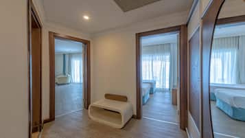 Habitación de hotel con piso de madera, un banco y una cama con cabecera azul.