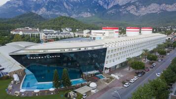 Un hotel con piscina, rodeado de montañas.