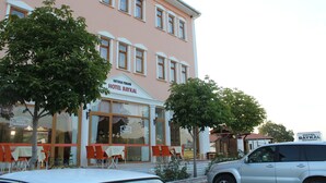 A hotel with a pink facade, multiple windows, and a sign reading "HOTEL BAYKAL". - Hotel Baykal (Bogazkale)