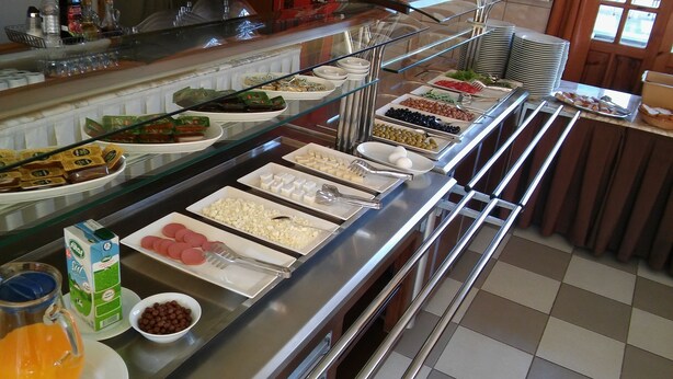 A buffet with various food items and utensils. - Hotel Baykal (Bogazkale)