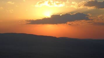 A sunset over a mountain range with a clear sky.