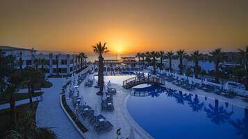 Alberca al aire libre, sombrillas en la alberca y camastros