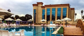 Una piscina cubierta, una piscina al aire libre, tumbonas