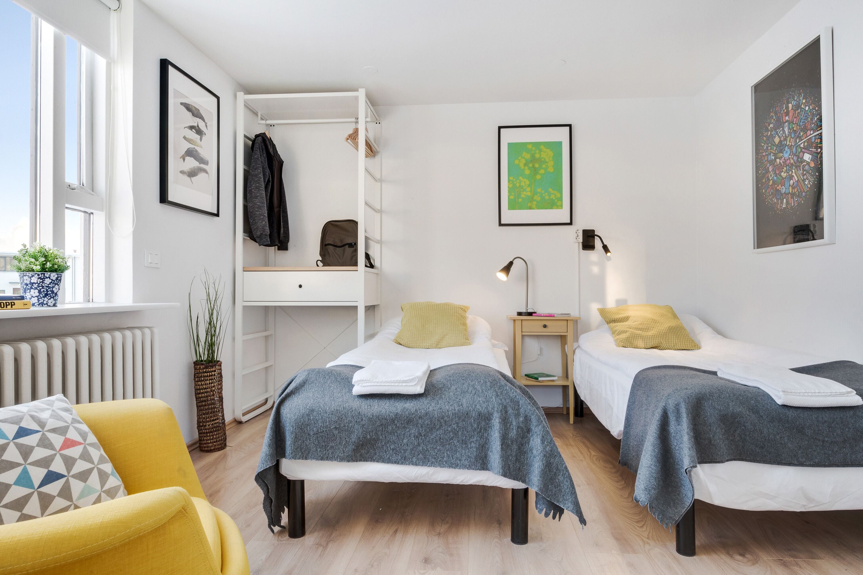 Une chambre moderne avec deux lits, un bureau intégré et une fenêtre donnant sur un beau paysage.