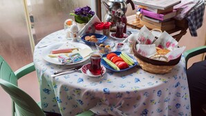 Una mesa servida con diferentes alimentos y una cafetera, indicando un ambiente para desayunar o picar algo.