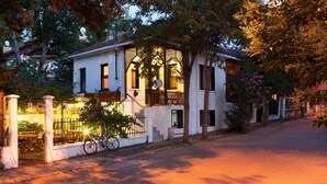 Un edificio blanco con un balcón, una bicicleta y una reja.