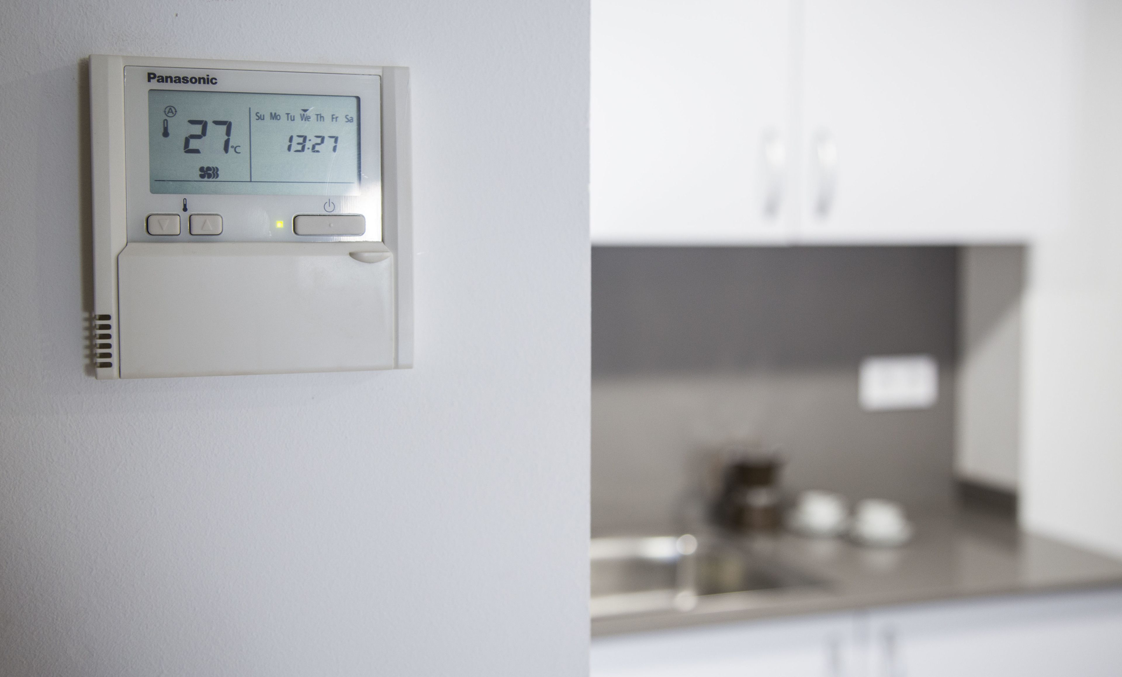 Een Panasonic thermostaat waarop 27°C en 13:27 staat aangegeven.