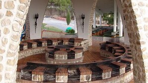 A stone-walled outdoor seating area with a circular arrangement of benches and a central fire pit. - Balneario de Alicún de las Torres (Villanueva de las Torres)