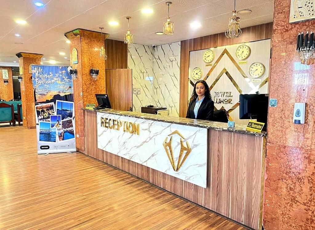 A reception desk with a marble top and a logo, a clock, and a sign for 'JEWEL KURASS'.
