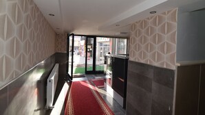 A hallway with patterned walls, a red carpet, and a view of the outside. - Saltuk Otel (Erzurum)